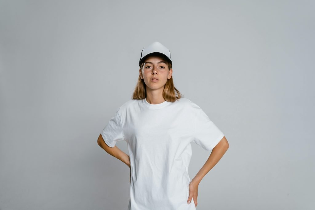 Female model wearing a standard fit 160gsm white cotton t-shirt with a cap.