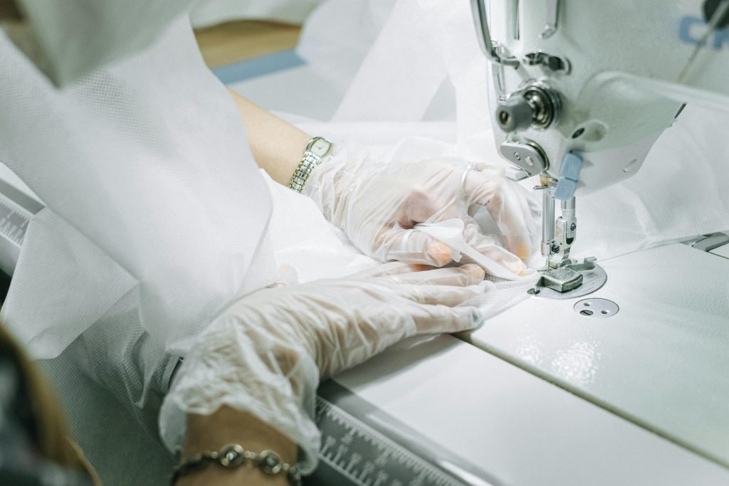 Close up of a worker using a sewing machine to make custom clothes.