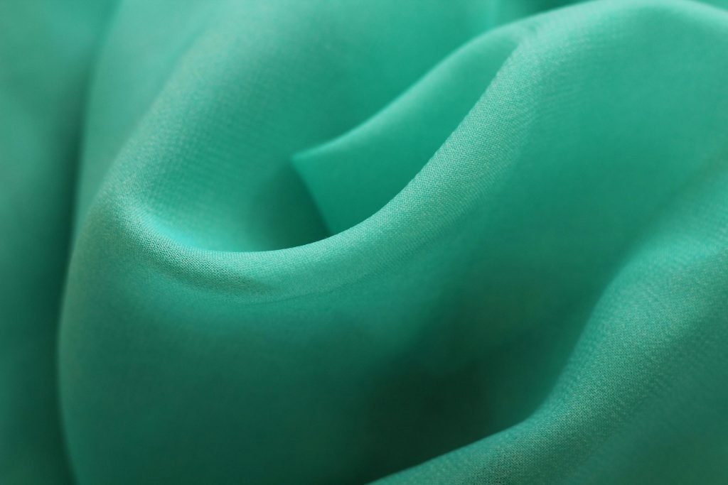 Close up of high-quality green fabric used for private label clothing.