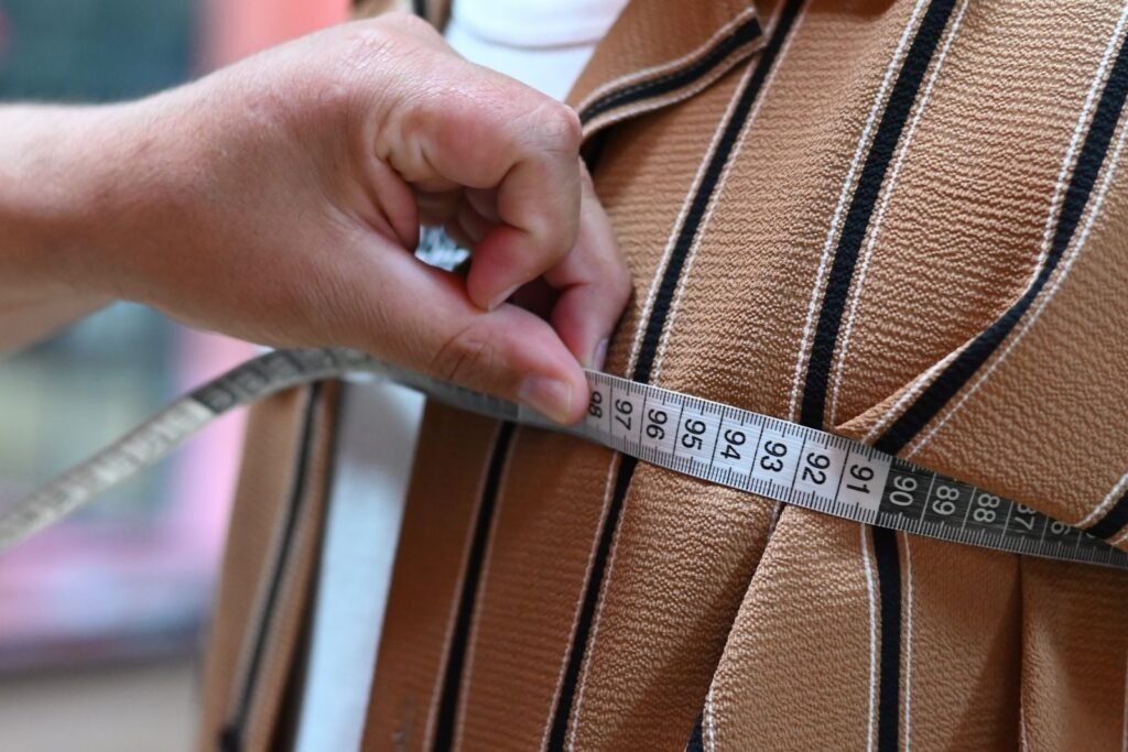 Tailor measuring fabric with a tape for garment shrinkage testing